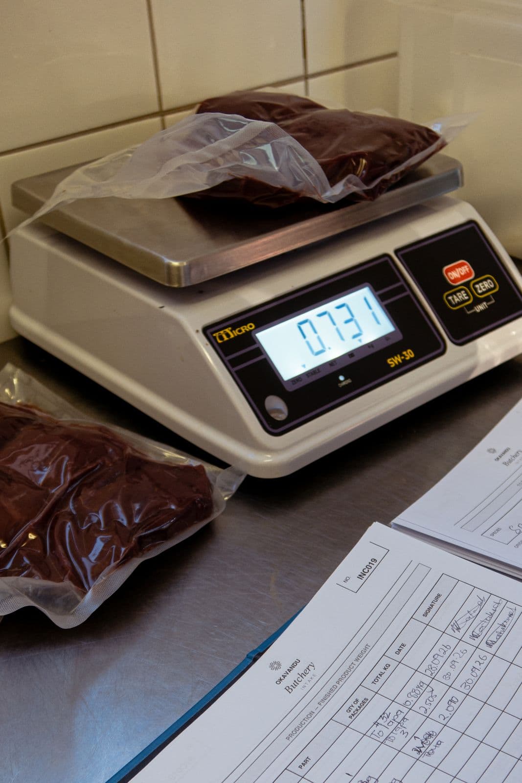 Vakuumverpacktes Fleisch auf der Waage, daneben das Protokoll der Okavandu-Metzgerei.