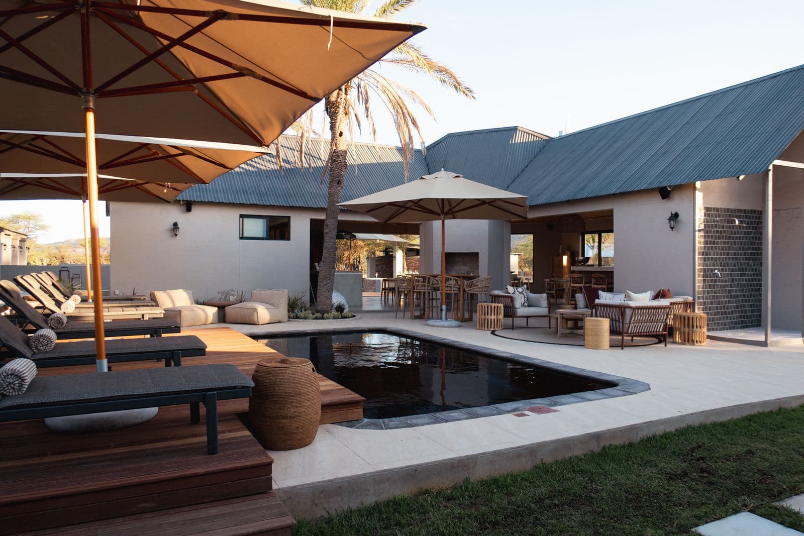 Der Pool der Lodge mit Holzdeck und Liegen, dahinter die Lapa.