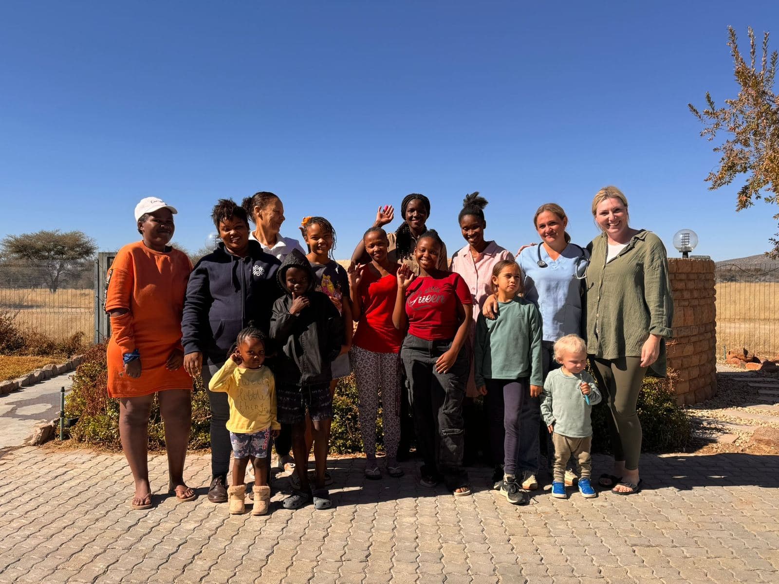 Die Familien, die auf der Farm leben, mit ihren Kindern, Katharina Drescher und der Ärztin vor dem Farmbüro.